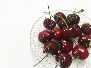 Cherries on glass dish on white background