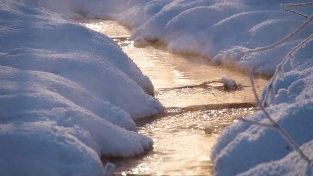 Vapor over small creek in winter under Sun rays. Novosibirsk, Siberia, Russia