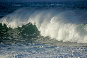 Seascape with large breaking wave and water spray.