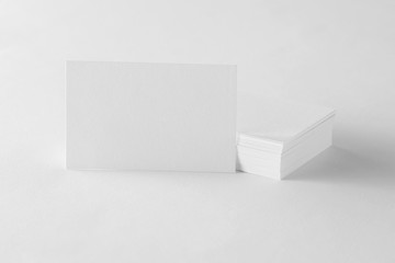 Mockup of single business card at cards stack on design paper