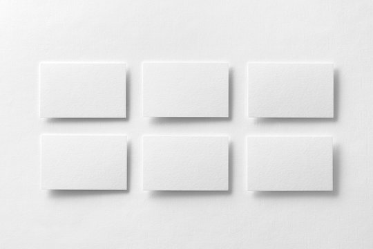 Mockup of white business cards arranged in rows at design paper