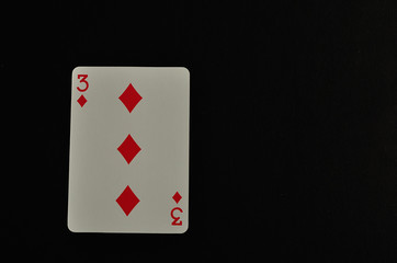 Playing card. Three of diamond isolated on a black background