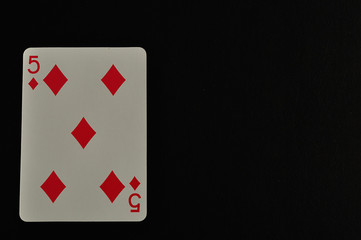 Playing card. Five of diamond isolated on a black background