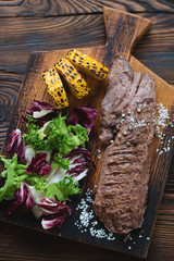 Grilled machete beefsteak served with corn and fresh salad mix