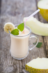 Yogurt and smoothie with melon on a wooden table.