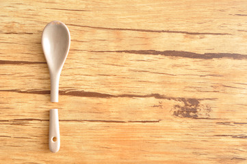 A broken beige glass teaspoon