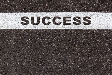 word success in white line on asphalt road texture background