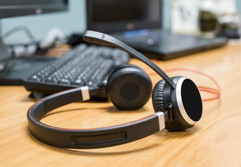 Obraz na płótnie Canvas Headphones, with laptop on table, call center service