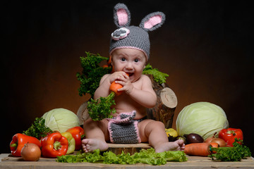baby in the Bunny suit with different vegetables