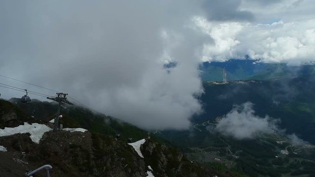 Cableway with open seats in mountains in cloudy weather
