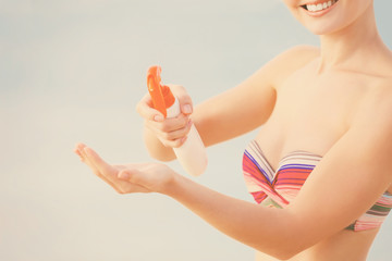 Young woman applying sunscreen on hand. Skin care concept.