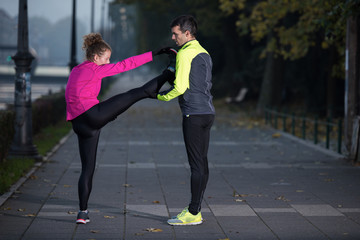 a young couple warming up before jogging