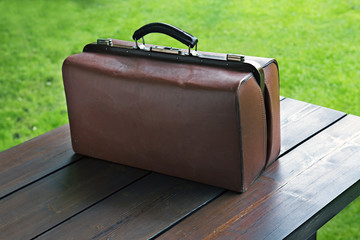 Old suitcase on a wooden table