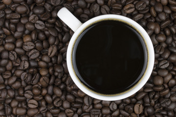 black coffee in cup on coffee beans background