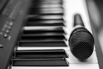 Close up microphone on piano keyboard in music studio. Music concept.