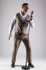 Silhouette of singer with microphone on grey background. Singer concept.