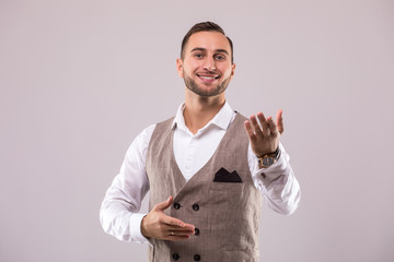 Handsome man open palm over grey background