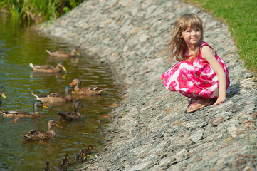 little girl on the bank of a pond