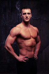 Fototapeta na wymiar Portrait of athletic male model posing with bare torsо