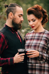 Portrait of a beautiful bride and groom with glasses of wine at a wedding feast.