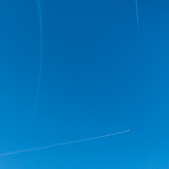 Tree jet planes carry out aerobatic maneuvres in blue sky.