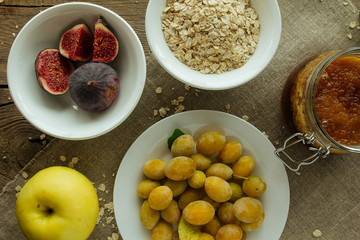 Figs, plums, oatmeal flakes and honey top view