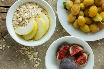 Oatmeal flakes, apples, figs and plums top view