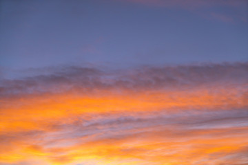 Dramatic sunset sky with orange colored clouds in summer season.