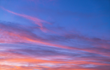 Dramatic sunset sky with orange colored clouds in summer season.