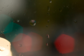 Tropfen an Scheibe mit verschwommenen Lichtern