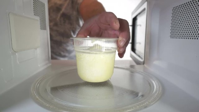  Heating frozen cheese soup container in the microwave oven. Inside view