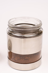 Glass jar with grated coffee over white background