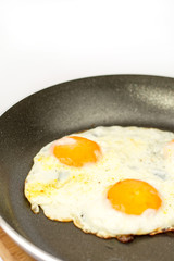 Closeup macro view of fried eggs in teflon frying pan