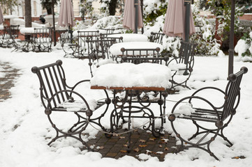 iron table and chairs covered with snow