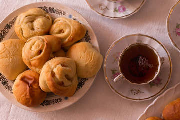 
delicious hot homemade cakes and a cup of tea on a white tablecloth at home at the table