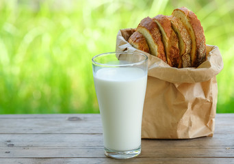 Bread cut pieces  with milk glass on wooden table,green blurred