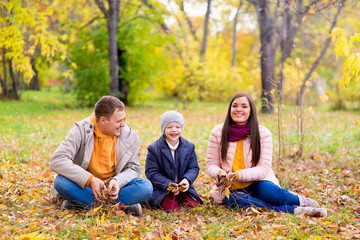 Fototapeta premium family playing with leaves autumn park
