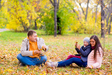 Fototapeta premium family playing with leaves autumn park