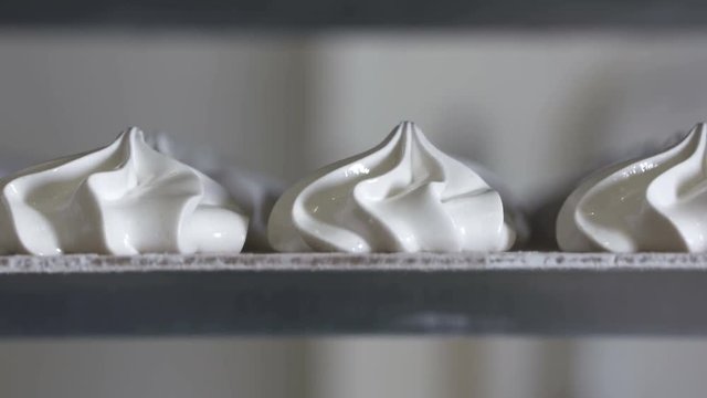 Confectionery factory production of sweet marshmallow. Trays on a rack with finished zephyr are cooled before packaging and shipping to candy store. Close-up tilt down