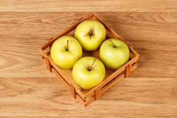Green apples in the wooden basket
