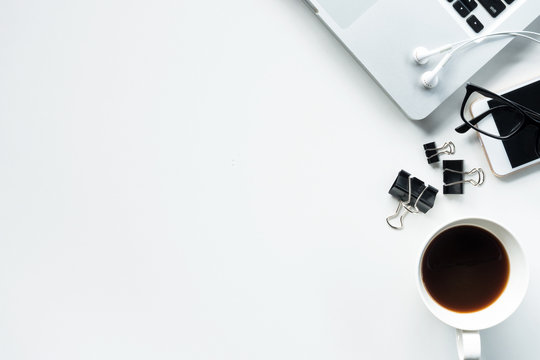 white office desk table with laptop, coffee, and supplies. Top view with copy space, flat lay.