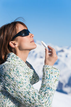 portrait d'une belle femme qui applique de l'&eacute;cran solaire sur sa bouche