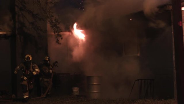 Firefighters fighting a fire at night in a residential neghborhood 
