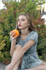 Beautiful girl is drinking juice through a straw