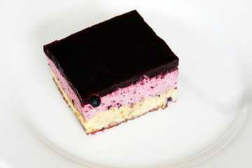 served dessert: blueberry cheesecake with jelly on white plate