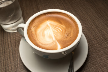 Hot Cappuccino Coffee on wooden table