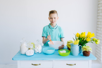 The child preparing dough in the kitchen