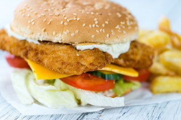 Wooden table with a fresh made Fish Burger