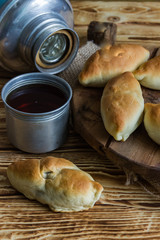 Russian pirozhki ,baked patties, on wooden cutboard