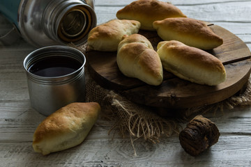 Russian pirozhki ,baked patties, on wooden cutboard
